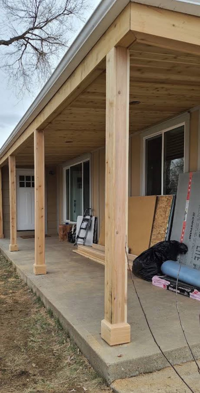 Cedar porch posts and plank soffit along a covered front porch
